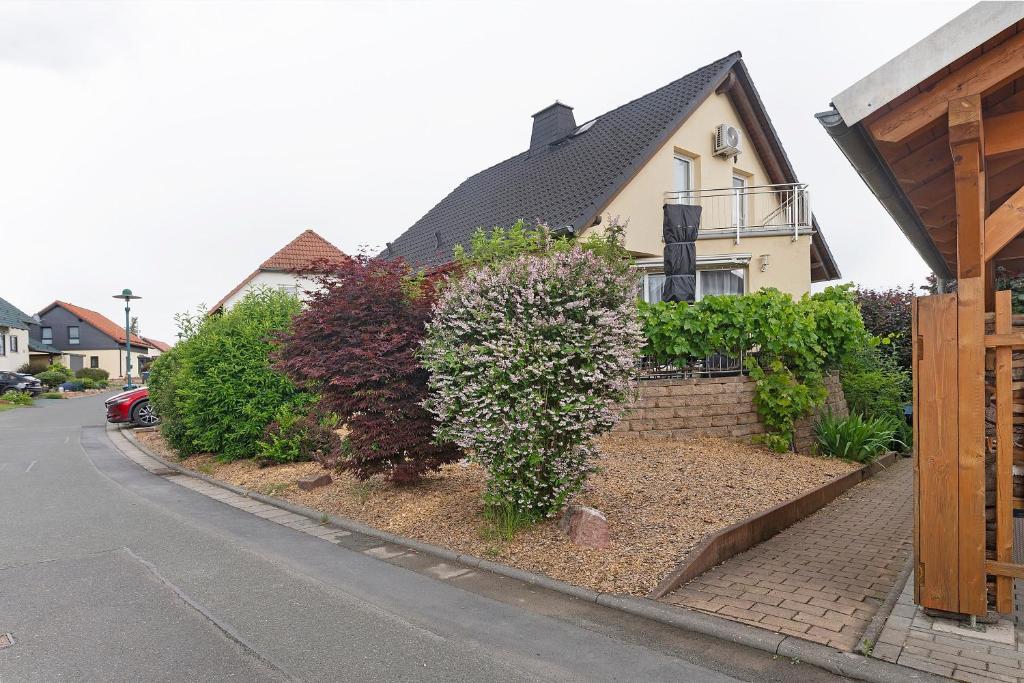 a house with a hedge in front of a street at Ferienwohnung sehr ruhig in Pößneck