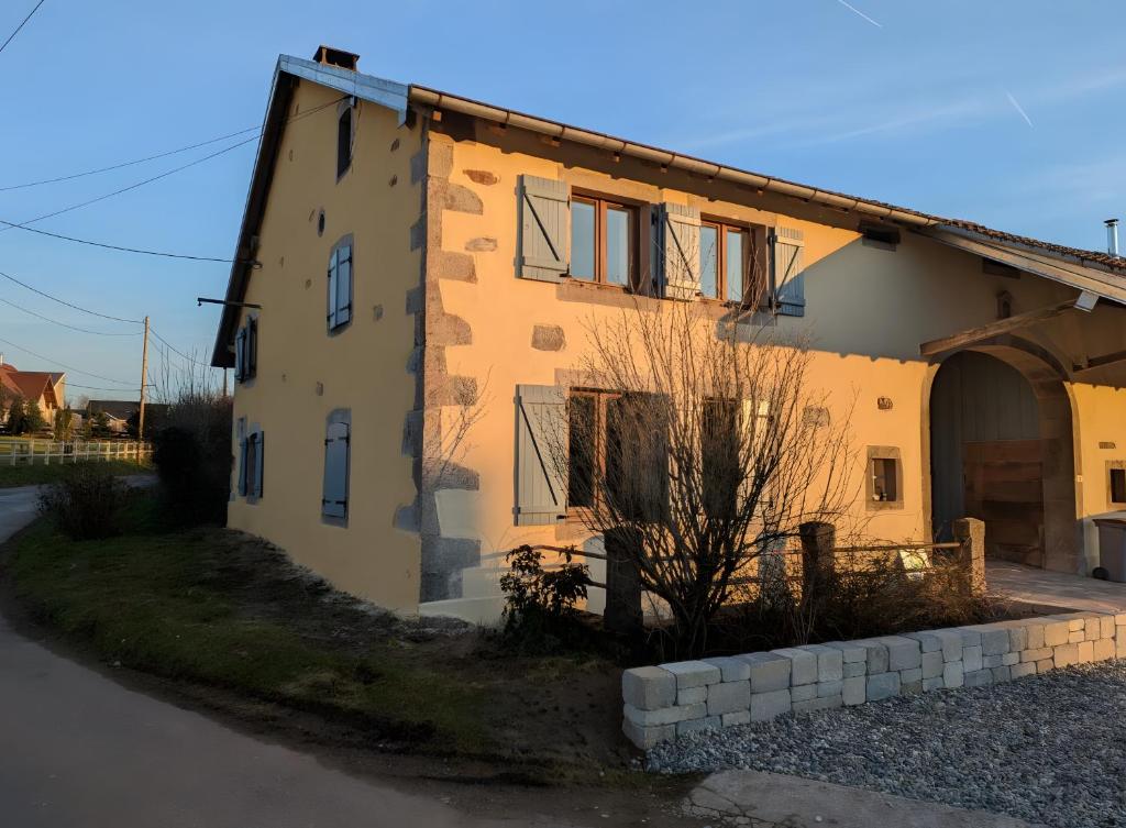 a yellow house with a building with a garage at Gite Les Sources in Champagney