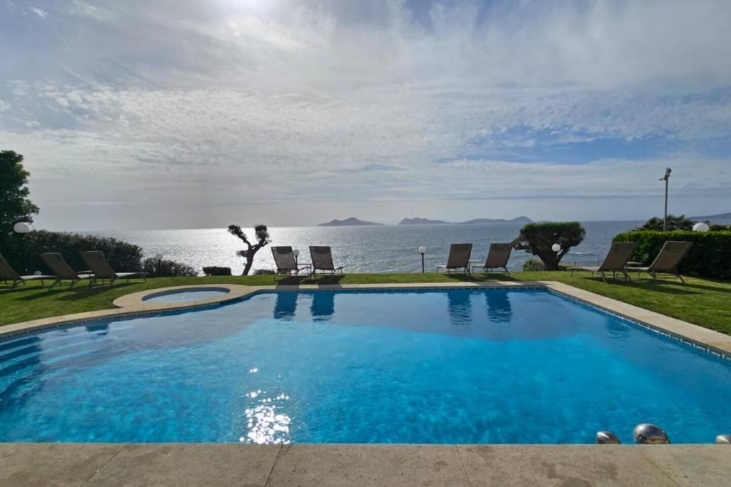 a large swimming pool with a view of the ocean at Oia Mar & Relax in Oya