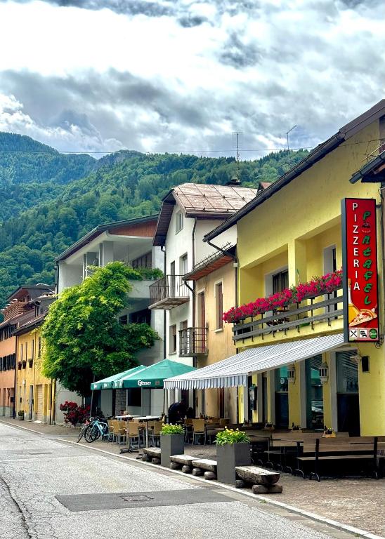 a group of buildings with tables and chairs on a street at Albergo Pontafel in Pontebba