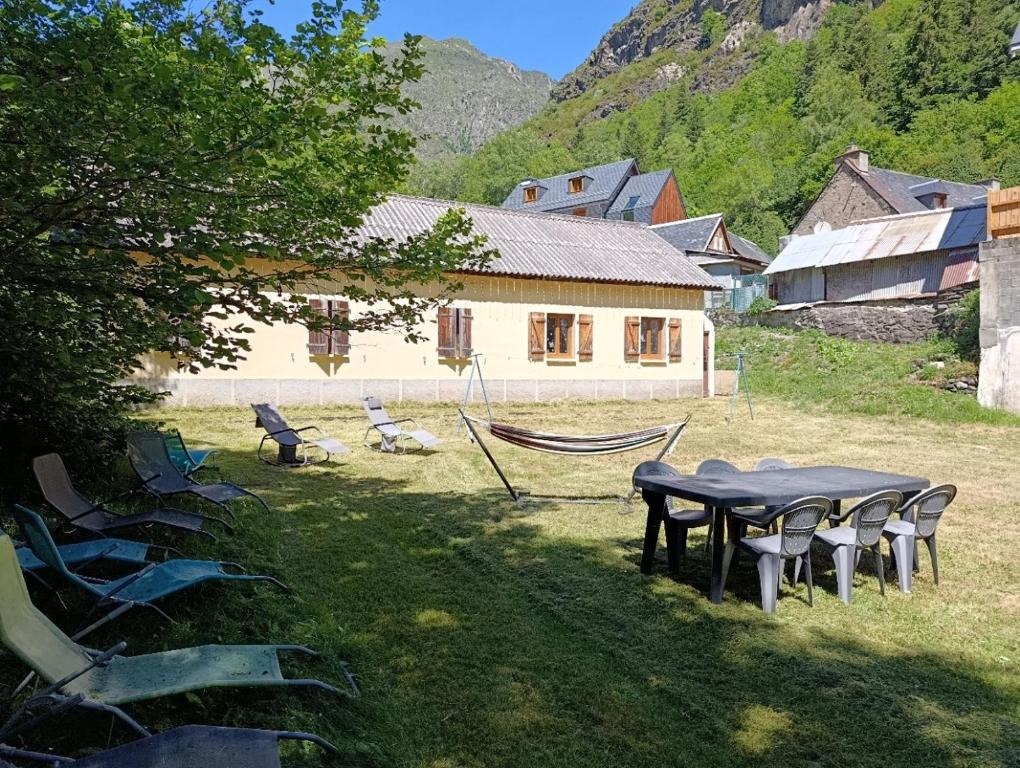a group of chairs and a table and a house at Gîte Espace et Montagne in Aragnouet
