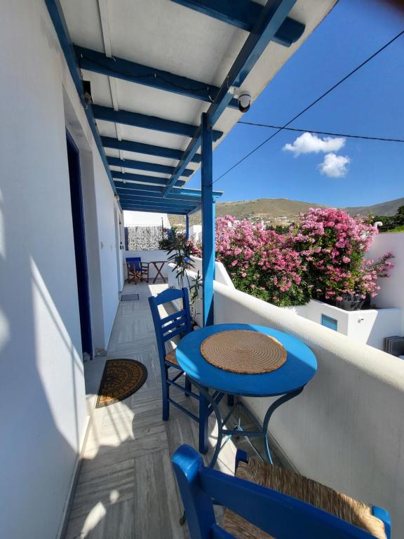 a blue table and chairs on a balcony with flowers at Manolia Home in Parikia