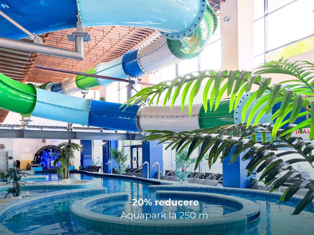 a water slide in a building with a pool at Hotel Aurora in Băile Olăneşti