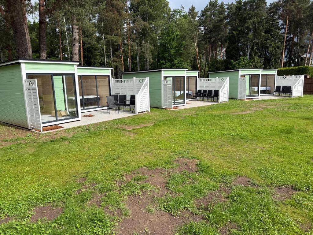 a row of green modular houses in a field at Teemeistri Camp in Tõrva