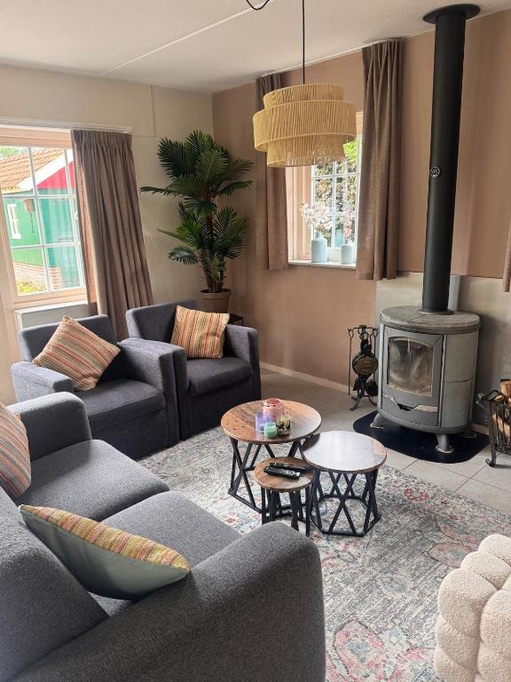 a living room with couches and a wood stove at Vakantiewoning Uutbloazen in Lievelde