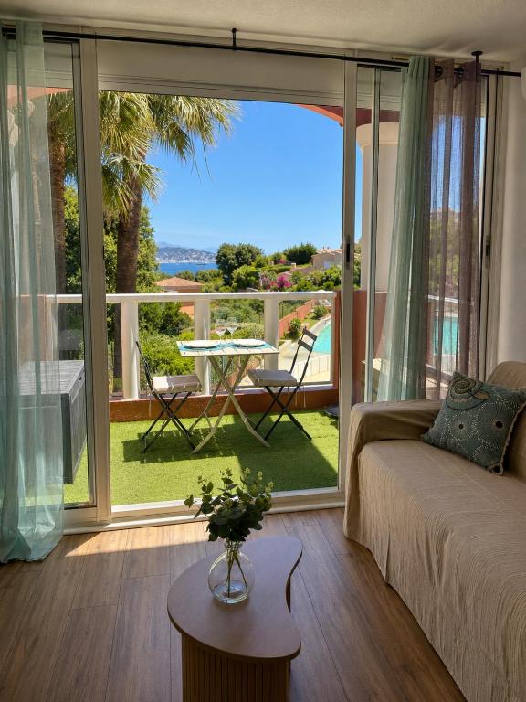a living room with a couch and a large window at Rousseau in Théoule-sur-Mer