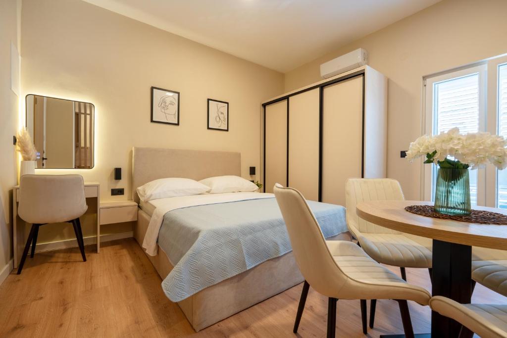a bedroom with a bed and a table and chairs at Guest house AnĐela in Neum