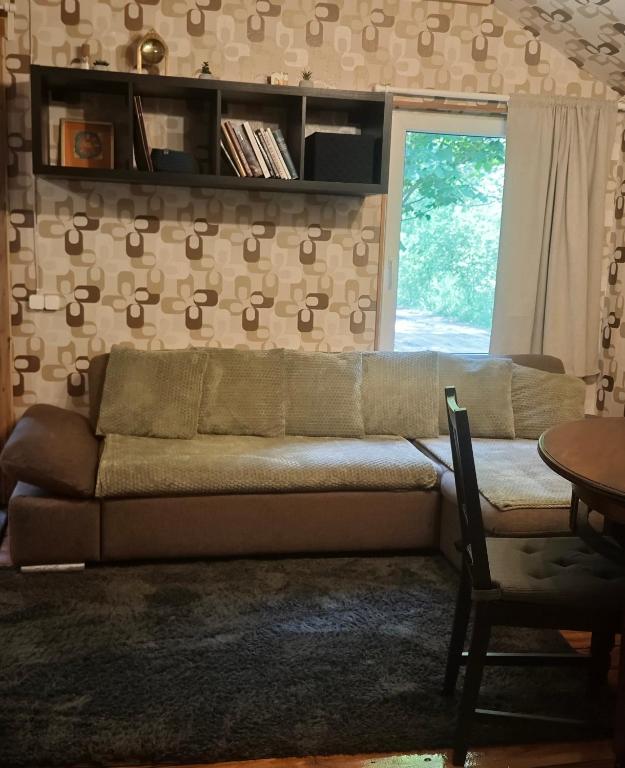 a living room with a couch and a table at Melleņu ligzda in Puršēni