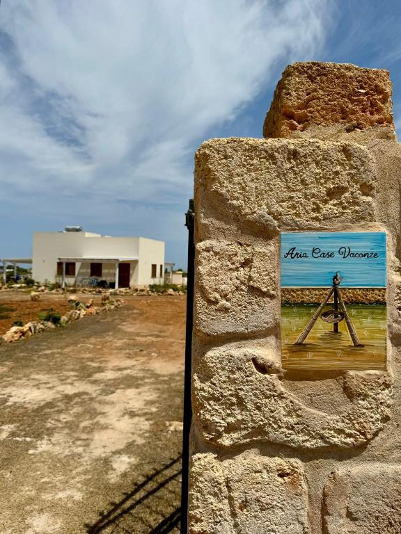 a sign on the side of a stone wall at Aria Case Vacanze - Frumento in Favignana