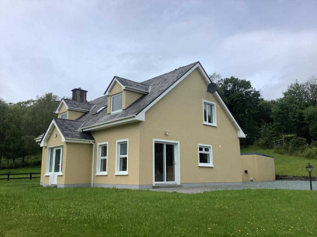 a yellow house with a gray roof at Kilmurry heights in Kenmare