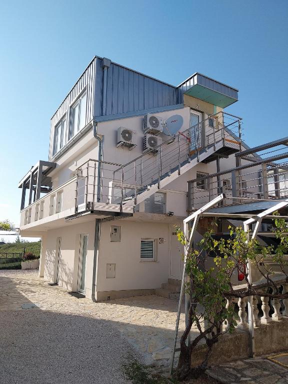a building with a balcony and stairs on it at Apartmani Lalu in Rtina
