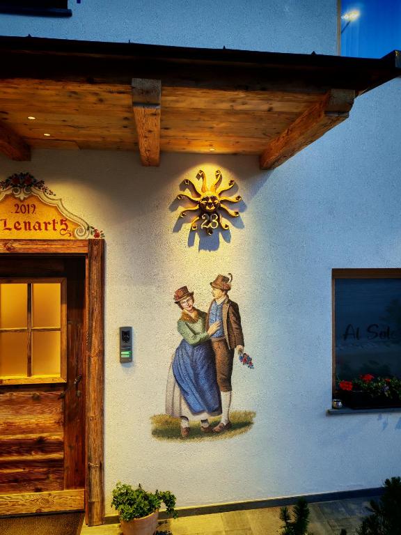 a painting of a woman and a man on the side of a building at Al Sole B&B Valcomelico in Santo Stefano di Cadore
