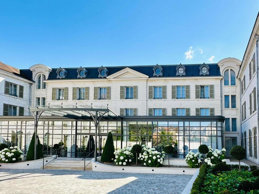 a large building with a lot of windows at La Licorne Hotel & Spa Troyes - MGallery Collection in Troyes