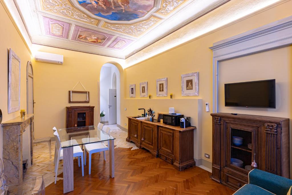 ein Wohnzimmer mit einem Tisch und einem Fernseher an der Decke in der Unterkunft Casa Ciseri in Siena