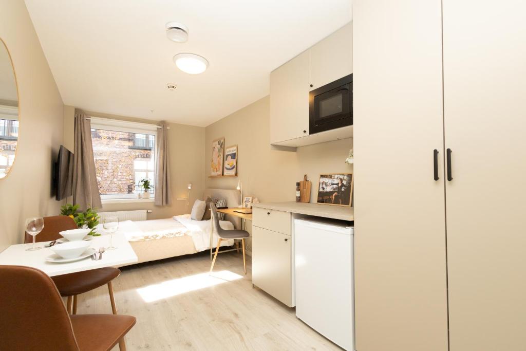 a small apartment with a kitchen and a bedroom at Kongens Gate Rooms in Kristiansand