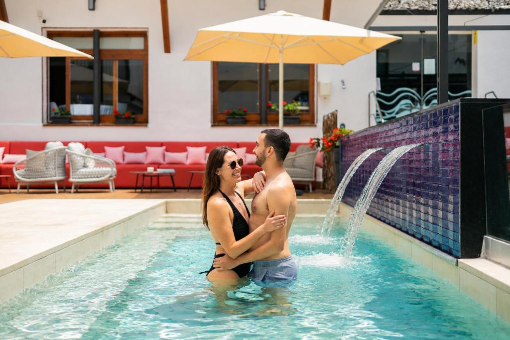 a man and a woman standing in a swimming pool at Neptuno Aparthotel in Calella