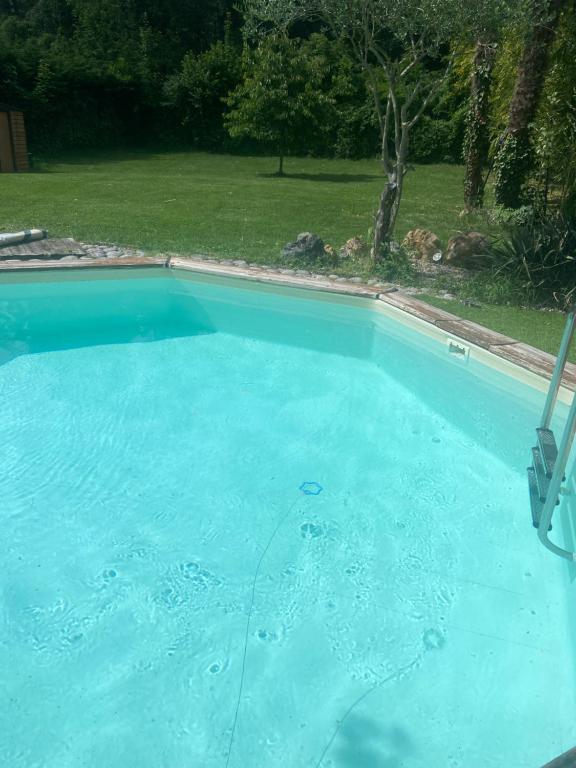 a large pool of blue water in a yard at Le wagon roulotte in Thorigny-sur-Marne