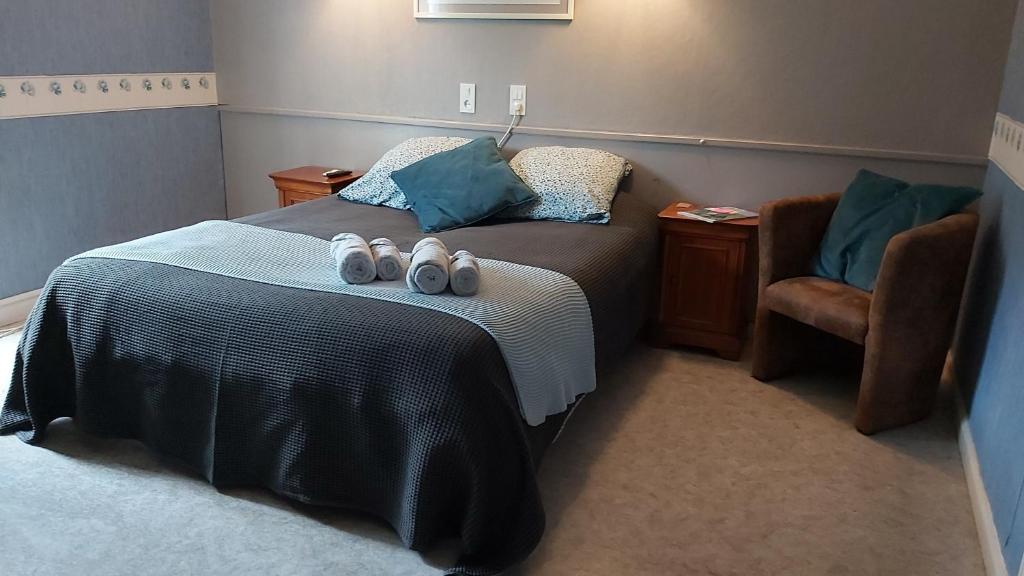 a bedroom with a bed with a pair of shoes on it at la Villa des Fleurs in La Bourboule