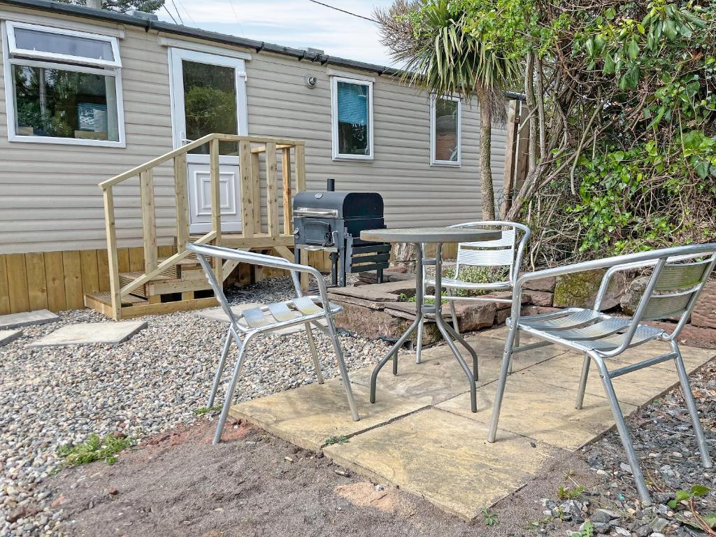 two chairs and a table in front of a grill at Forest Edge - Uk51739 in Oakmere