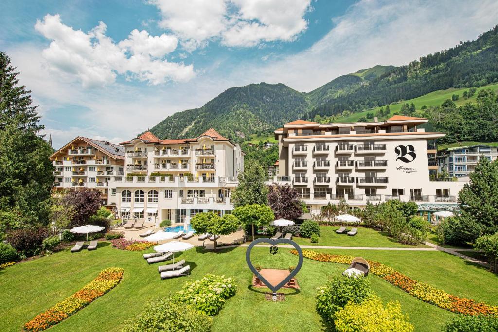 ein Hotel in den Bergen mit einem großen Garten in der Unterkunft Hotel Bismarck in Bad Hofgastein