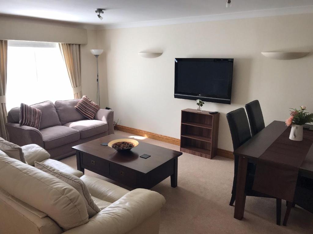 a living room with a couch and a tv at Orchard Sands in Beadnell