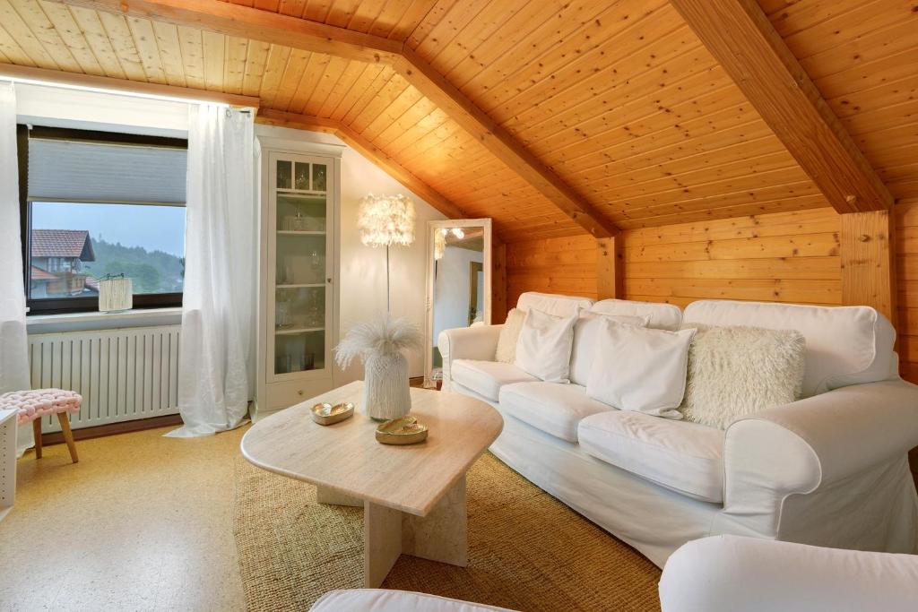a living room with a white couch and a table at Bayernseele - Bayerwald in Spiegelau