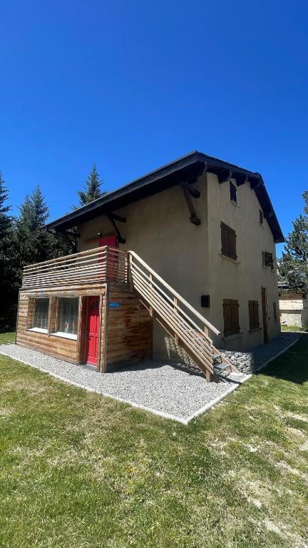 a large building with a red door on a grass field at Chalet Rec Fred in Matemale