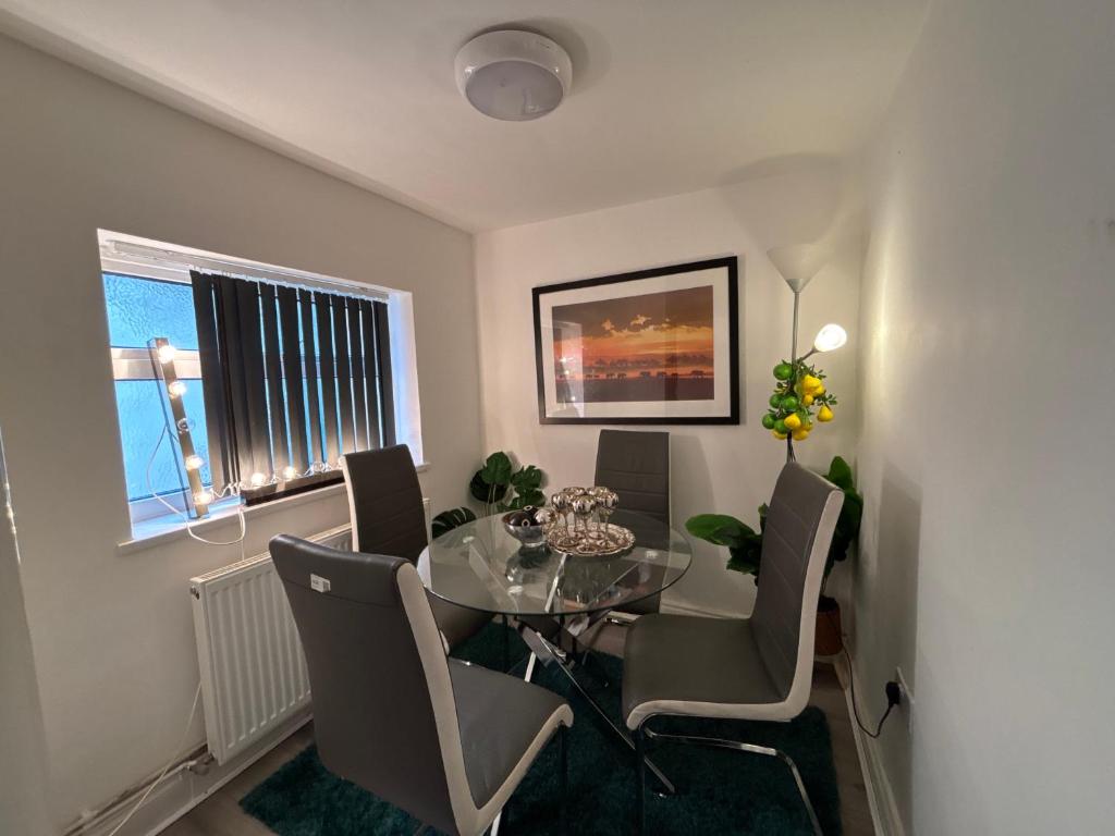 ein Esszimmer mit einem Glastisch und Stühlen in der Unterkunft Middlesbrough Lodge in Middlesbrough