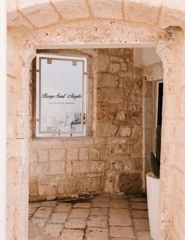 a window in a stone room with a plant at Borgo Sant' Angelo Exclusive House in Conversano