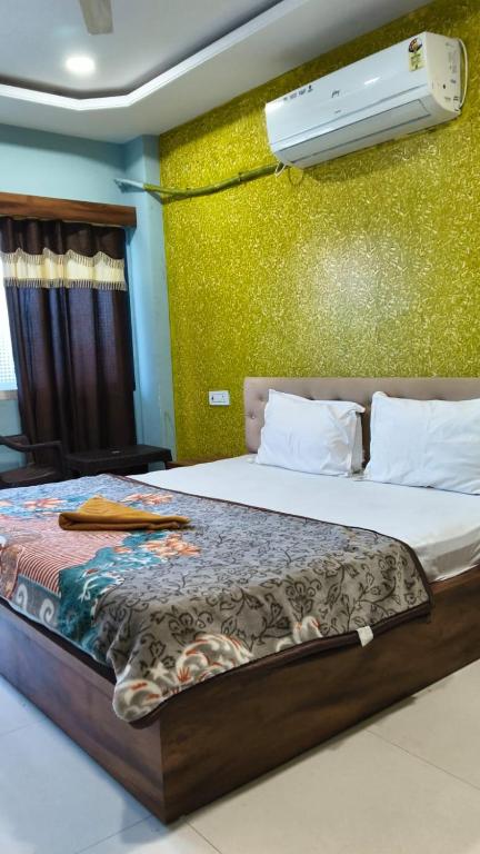 a bedroom with a bed with a air conditioner on the wall at Hotel Diamond in Gwalior