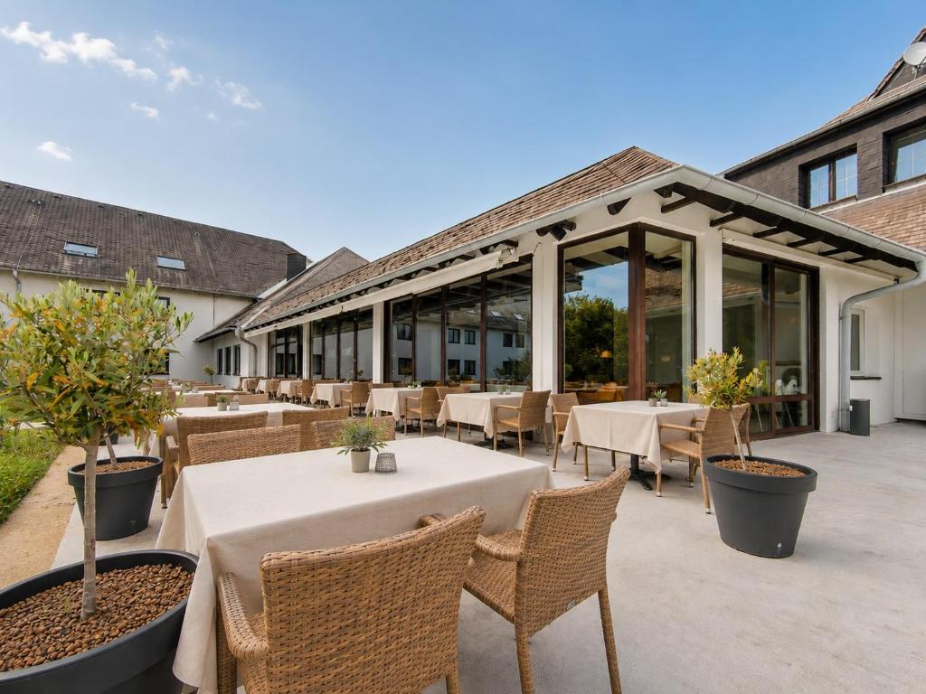an outdoor patio with tables and chairs and windows at Hotel Sachsengang - free parking, near U1 & U2 in Groß-Enzersdorf