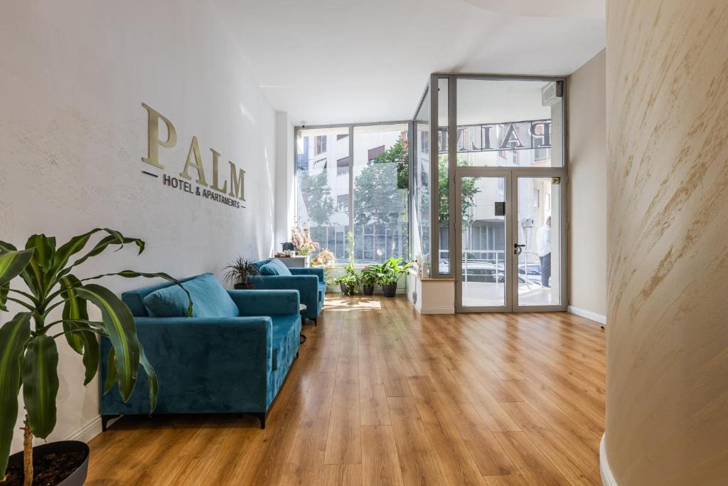 a living room with two blue couches and a wooden floor at Palm Beachfront Suites by PS in Durrës