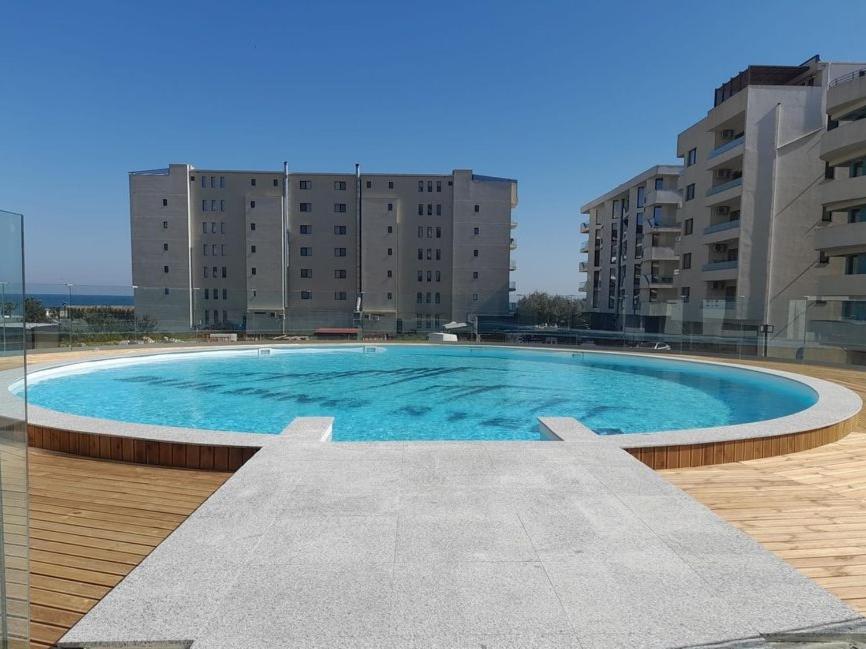 a large blue swimming pool with buildings in the background at NATALIA - Building Stefan Resort II in Năvodari