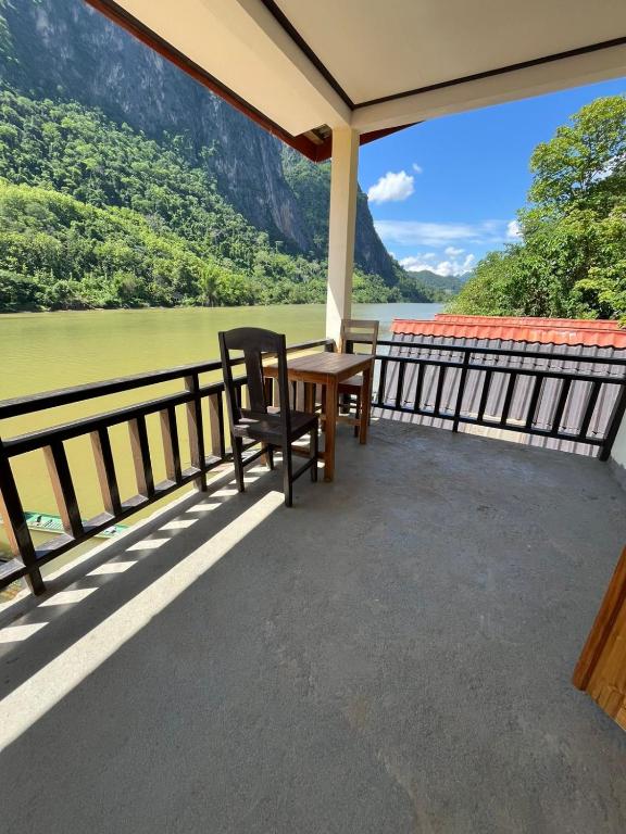 a balcony with a table and a view of a river at Views Backpackers Hostel in Nongkhiaw