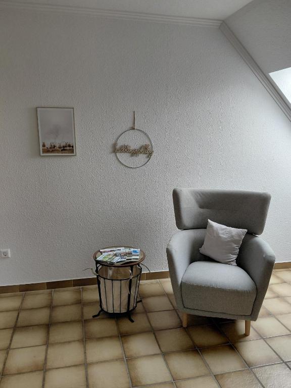 a living room with a chair and a table at Ferienwohnung Knoll in Lähden