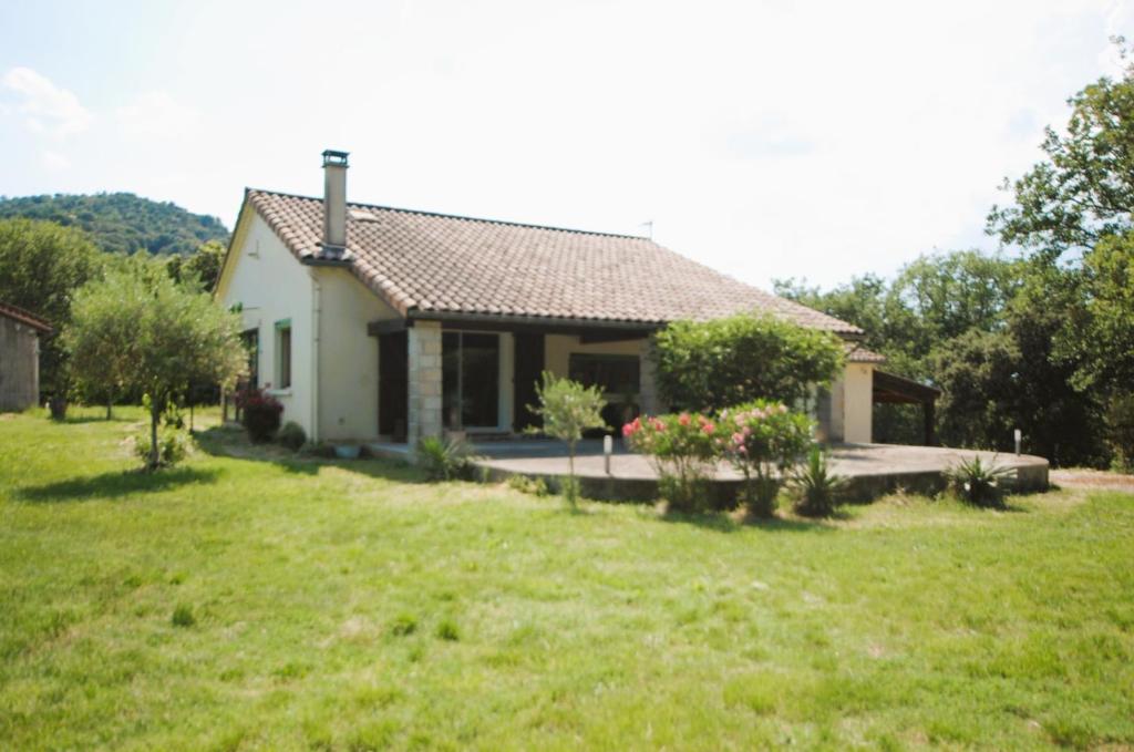 a small white house in a field of grass at La Chênaie Gîte in Sampzon