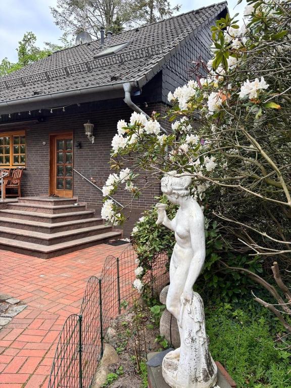 a statue of a boy in front of a house at Meisehof in Buchholz Aller