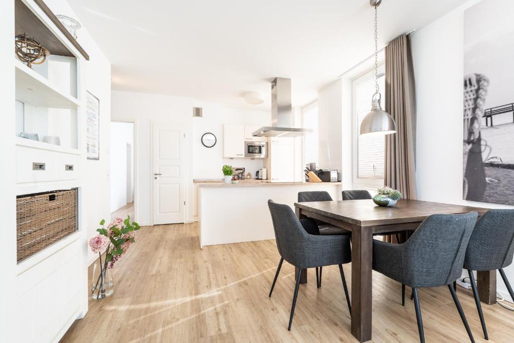 a kitchen and dining room with a wooden table and chairs at Südkap C-02 in Pelzerhaken