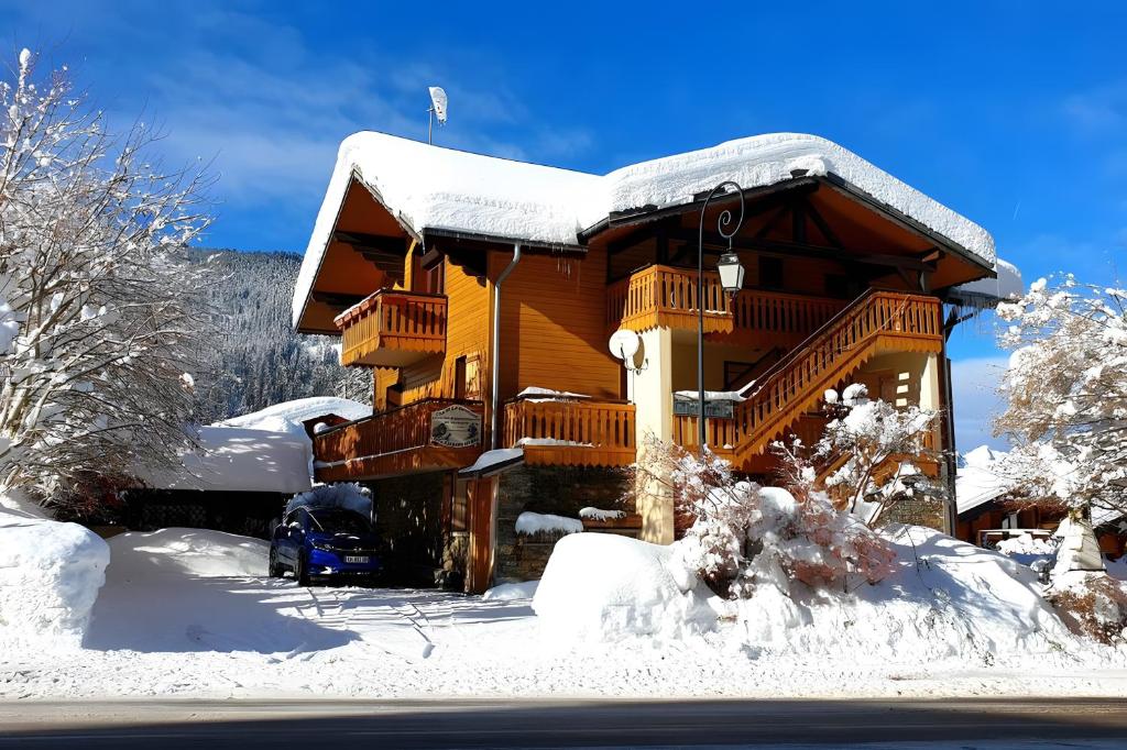 a house covered in snow with a car parked in front at Gentiane 7 pers - proche pistes in Châtel