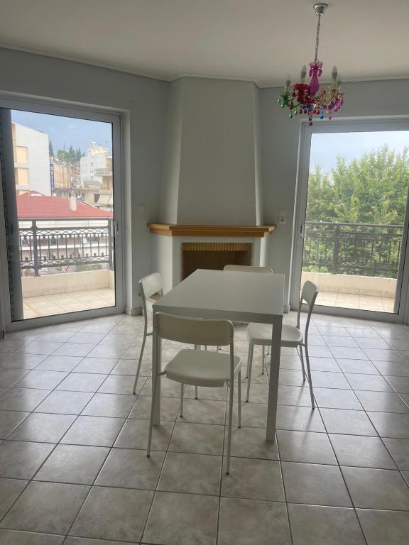 a dining room with a table and chairs and windows at RRooms in Nafpaktos