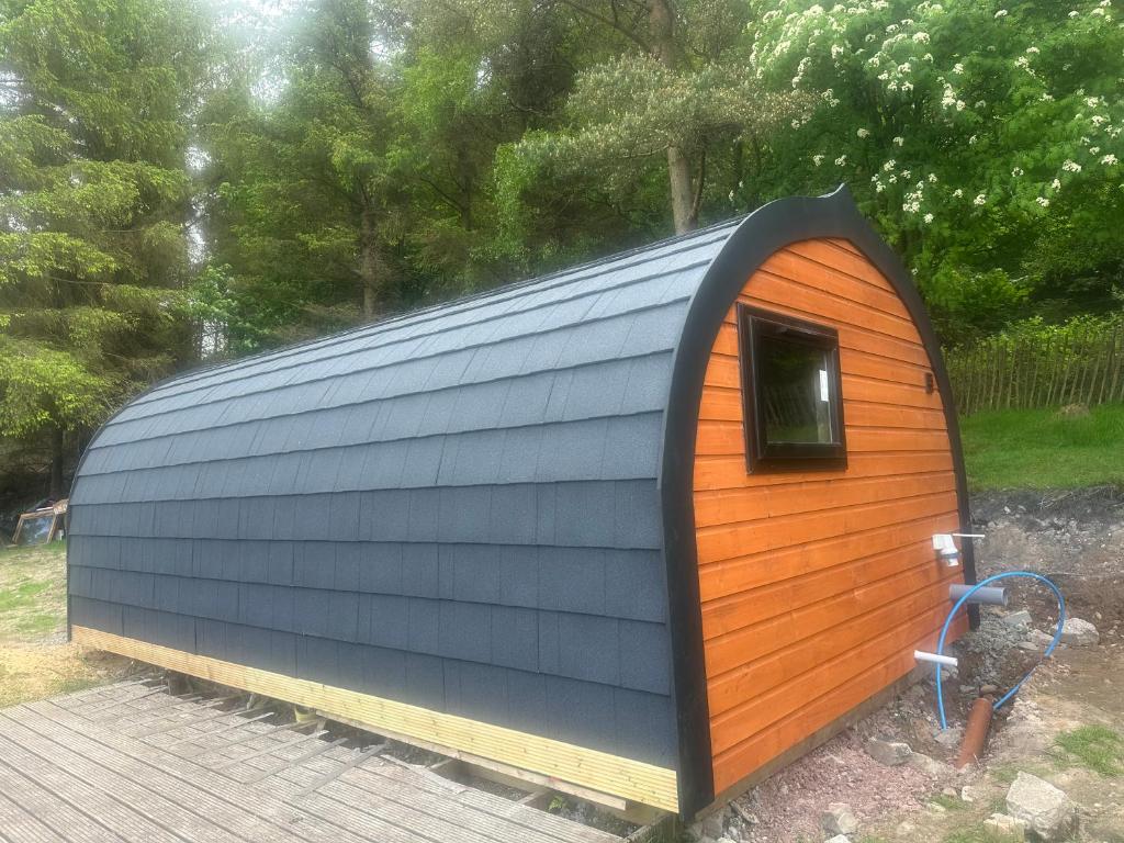 a blue and orange shed with a window at Pennygael in Lanark