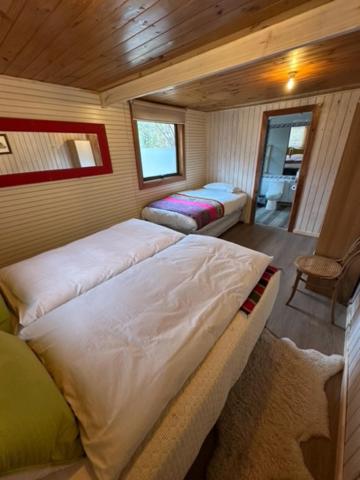 a small bedroom with two beds in a room at Hostal Piolet en Baños Morales in San José de Maipo