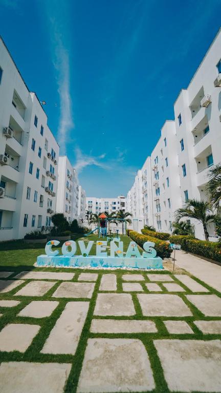 a sign in a park in front of some buildings at Familiar 5 piso in Coveñas