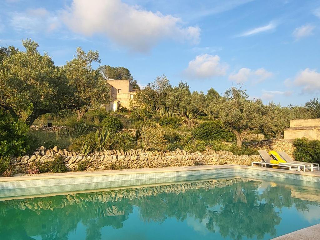 a swimming pool with a house in the background at Mas de Mingall in Les tres Cales