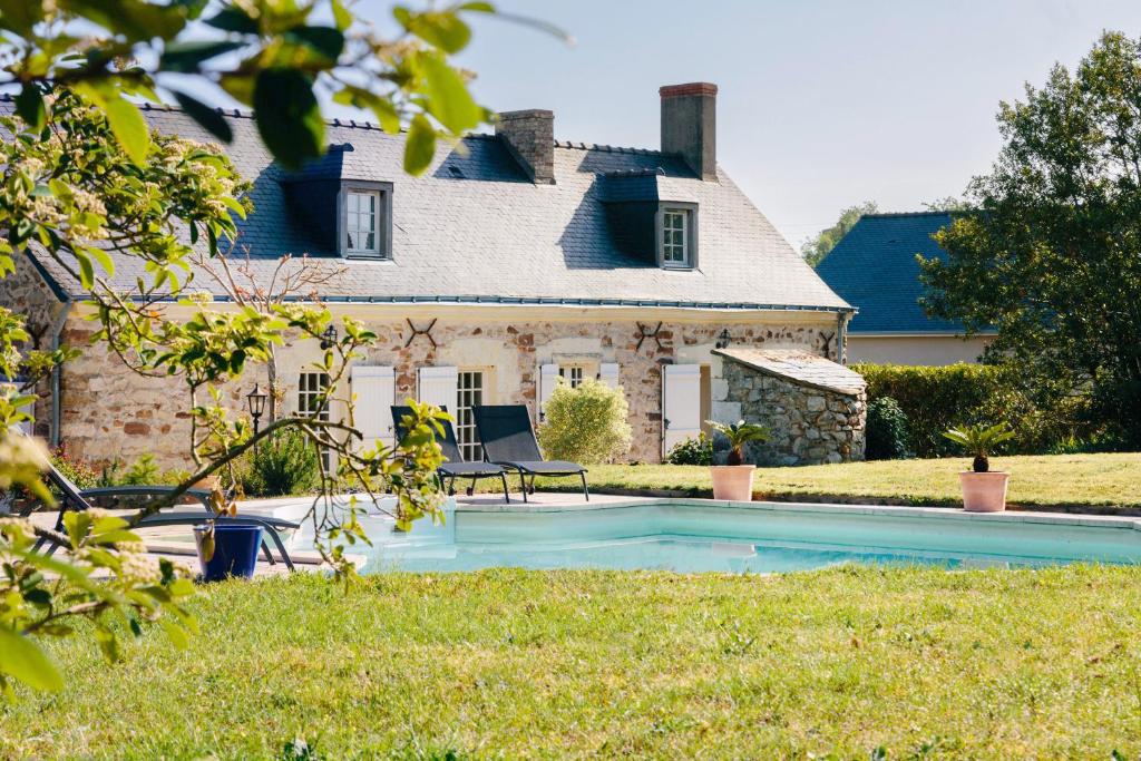 a house with a swimming pool in front of a house at La Boire Bavard in Blaison