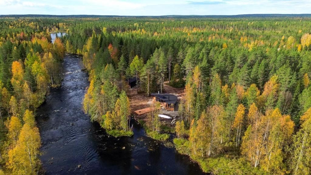 an aerial view of a lodge in the forest next to a river at Aurakoski 1 in Ranua
