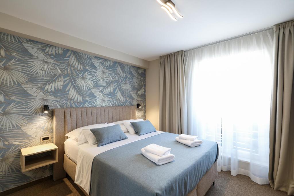a bedroom with a bed with towels on it at Rooms Sorićev Dvor in Preko
