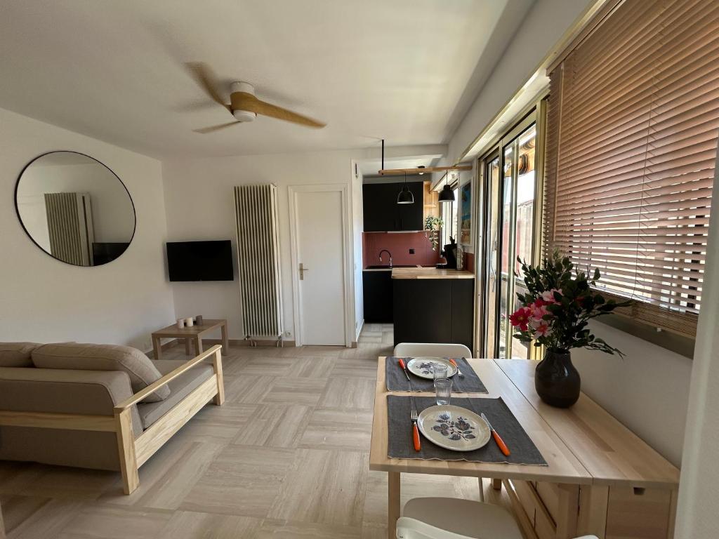 a living room with a table and a couch at Chez Raka in Hyères