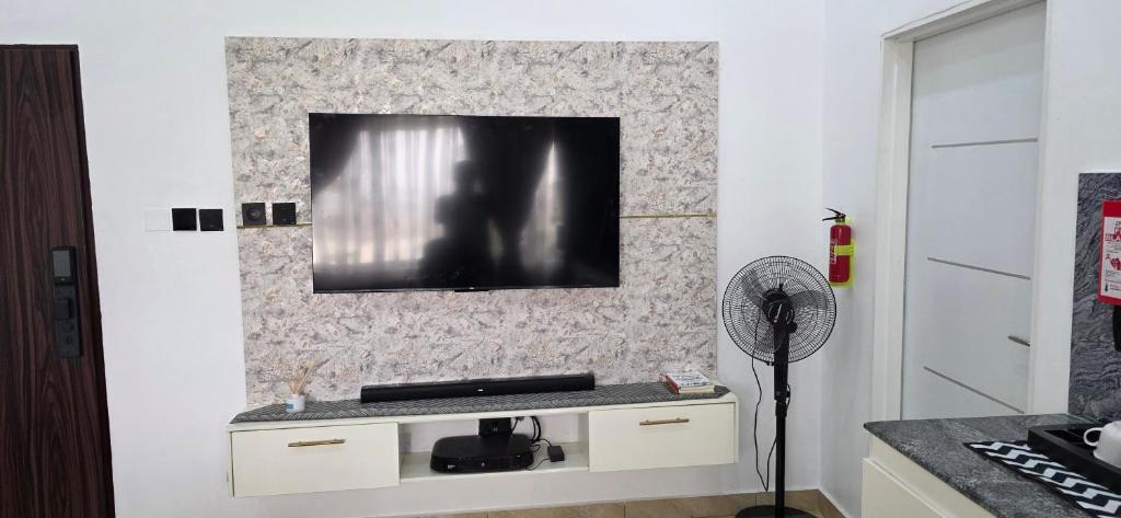 a living room with a tv on a wall at Axis Luxury 1 bedroom Studio Apartment in Abuja