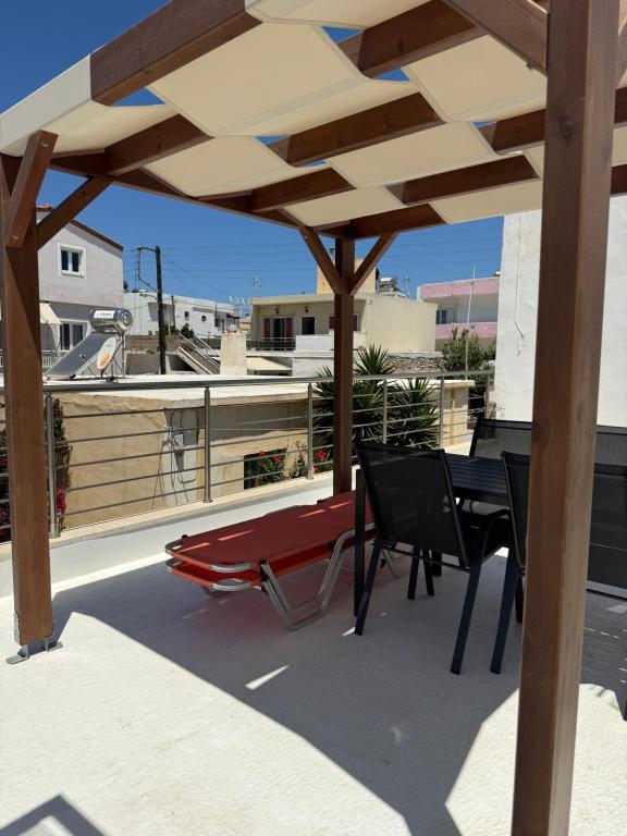 a patio with a table and chairs on a roof at Kalithea Palekastro in Palekastron